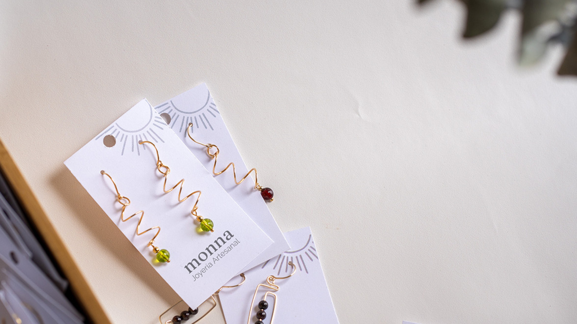 Aretes de Monna sobre tarjeta de la marca con fondo claro.