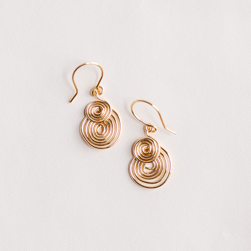 aretes espiral dorados y sobre fondo blanco