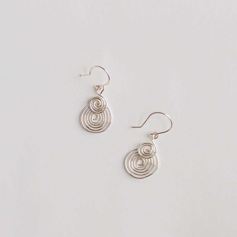 aretes espiral plateados y sobre fondo blanco
