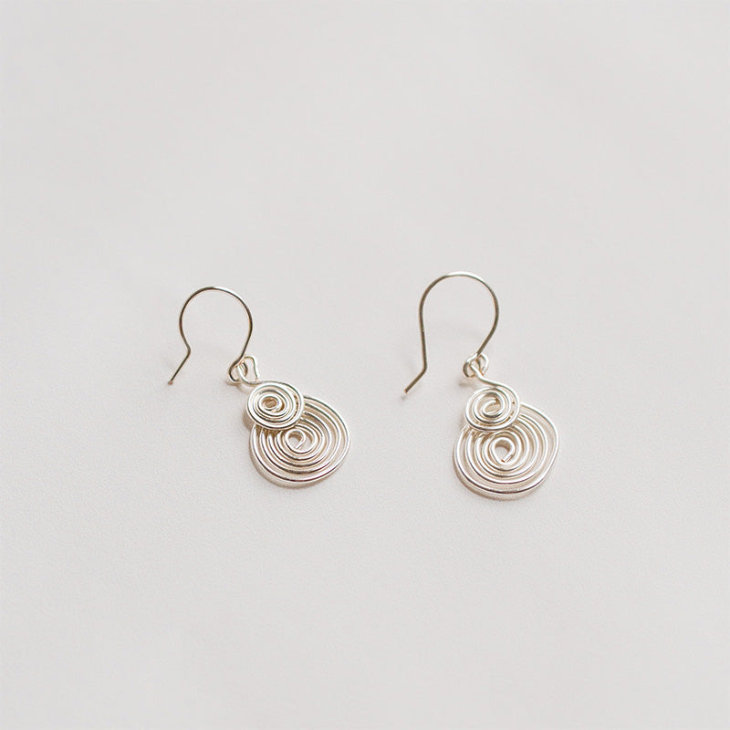 aretes espiral plateados  sobre fondo blanco